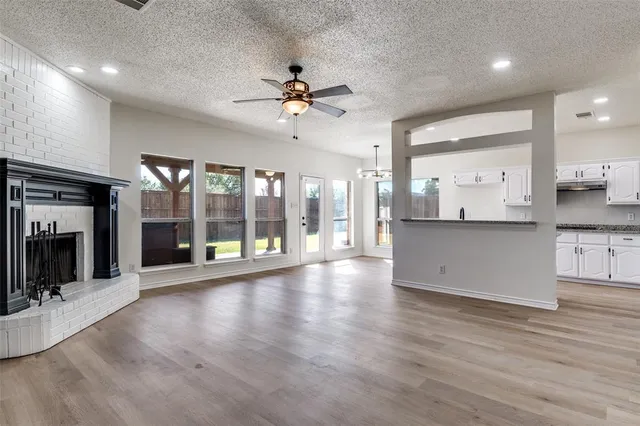 a view of a big room with wooden floor and windows