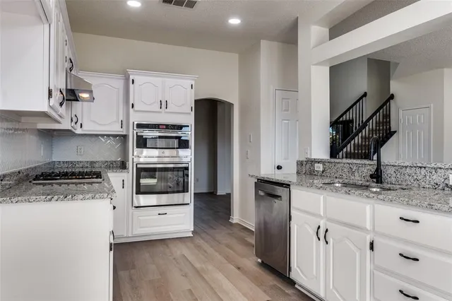 a kitchen with stainless steel appliances a stove a sink and a refrigerator