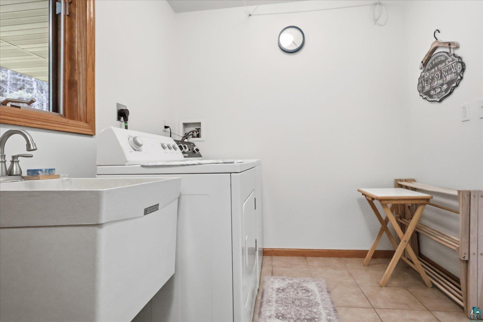 41 East Stark Road Esko, MN 55733 - Photo 15 of 19 Laundry area featuring a utility sink with a brushed nickel faucet, light-toned wall paint, and tiled flooring