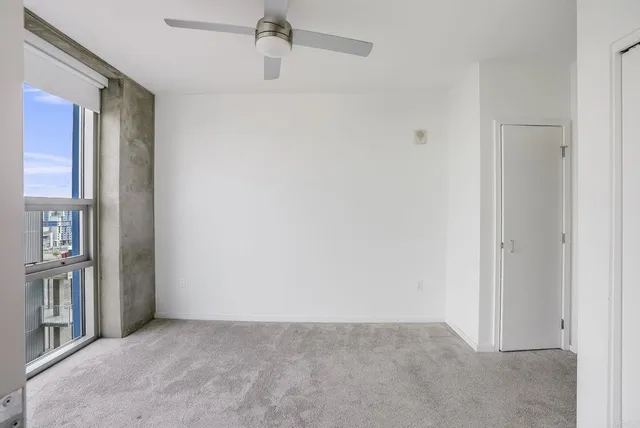 an empty room with windows and closet