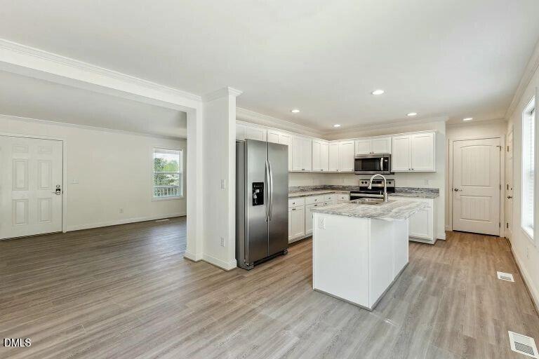 7120 Guess Road Hillsborough, NC 27278 - Photo 16 of 27 a kitchen with white cabinets and stainless steel appliances