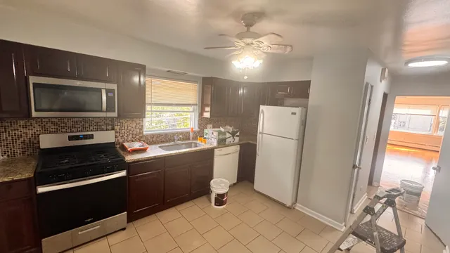 a kitchen with a refrigerator and a stove top oven