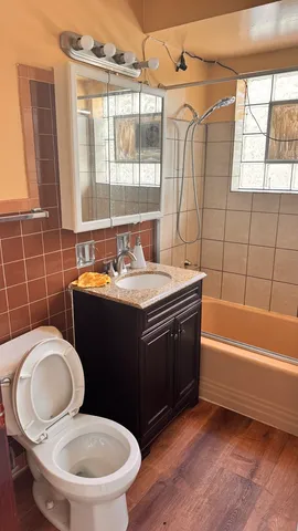 a bathroom with a sink toilet mirror and tub