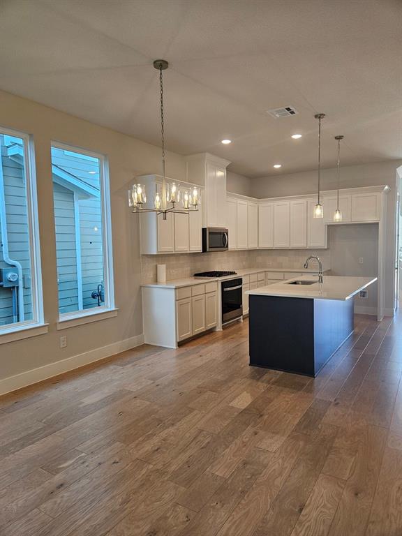 221 Chestnut Street Celina, TX 75009 - Photo 19 of 23 a large kitchen with kitchen island a island wooden floor and stainless steel appliances