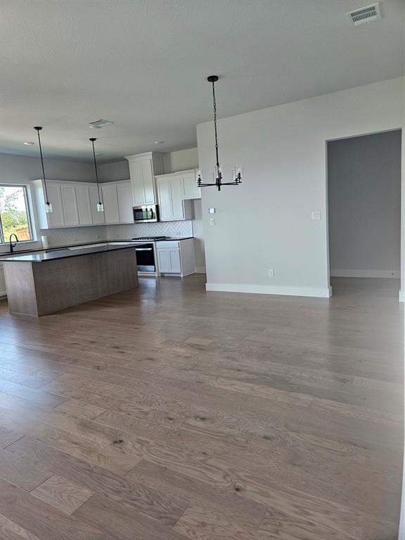 221 Chestnut Street Celina, TX 75009 - Photo 6 of 23 a large kitchen with kitchen island a sink stainless steel appliances and cabinets