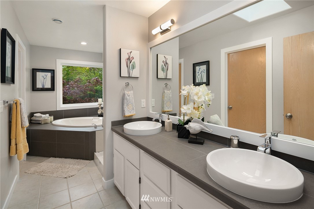 8515 Northeast 176th Street Bothell, WA 98011 - Photo 19 of 25 a bathroom with a tub double sink window and mirror