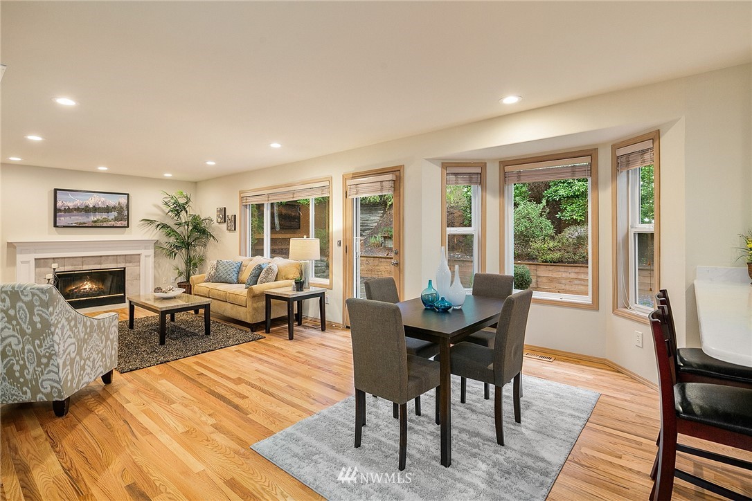 8515 Northeast 176th Street Bothell, WA 98011 - Photo 5 of 25 a dining room with furniture a fireplace and wooden floor