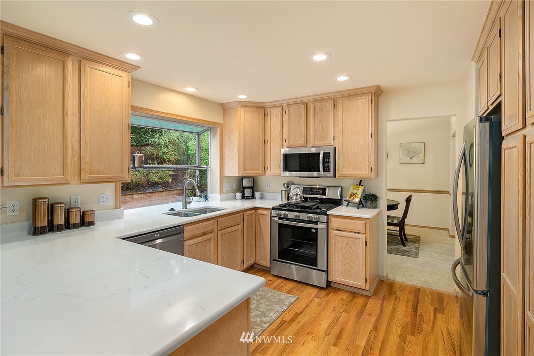 8515 Northeast 176th Street Bothell, WA 98011 - Photo 7 of 25 a kitchen with stainless steel appliances a stove sink microwave and cabinets