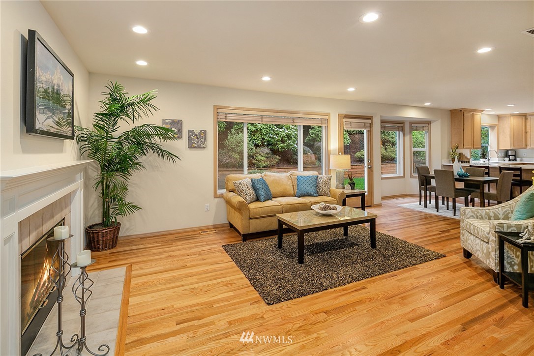 8515 Northeast 176th Street Bothell, WA 98011 - Photo 10 of 25 a living room with furniture a fireplace and a potted plant with wooden floor