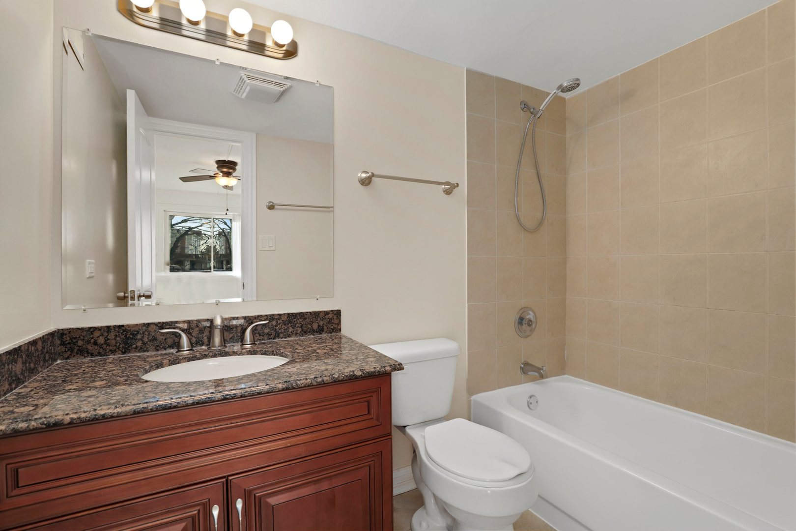 5509 Chateau Drive, Unit 1 Rolling Meadows, IL 60008 - Photo 14 of 16 a bathroom with a granite countertop sink toilet a mirror and shower