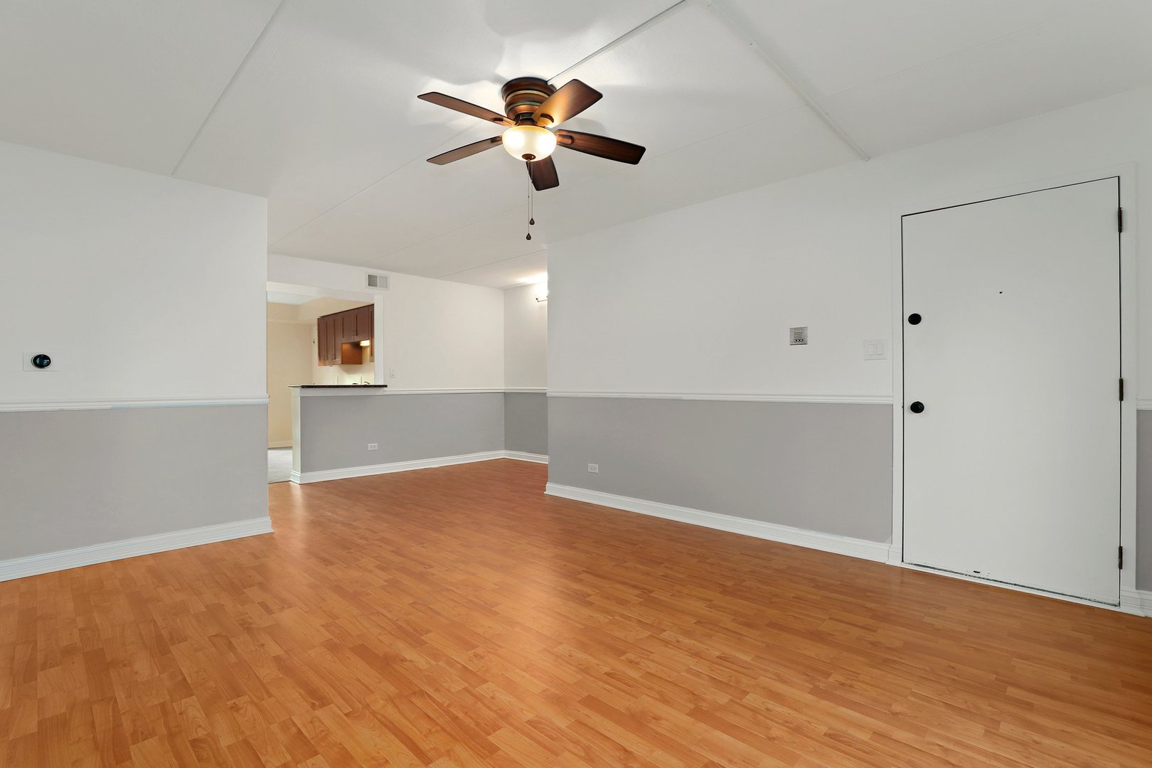 5509 Chateau Drive, Unit 1 Rolling Meadows, IL 60008 - Photo 4 of 16 an empty room with wooden floor chandelier fan and windows