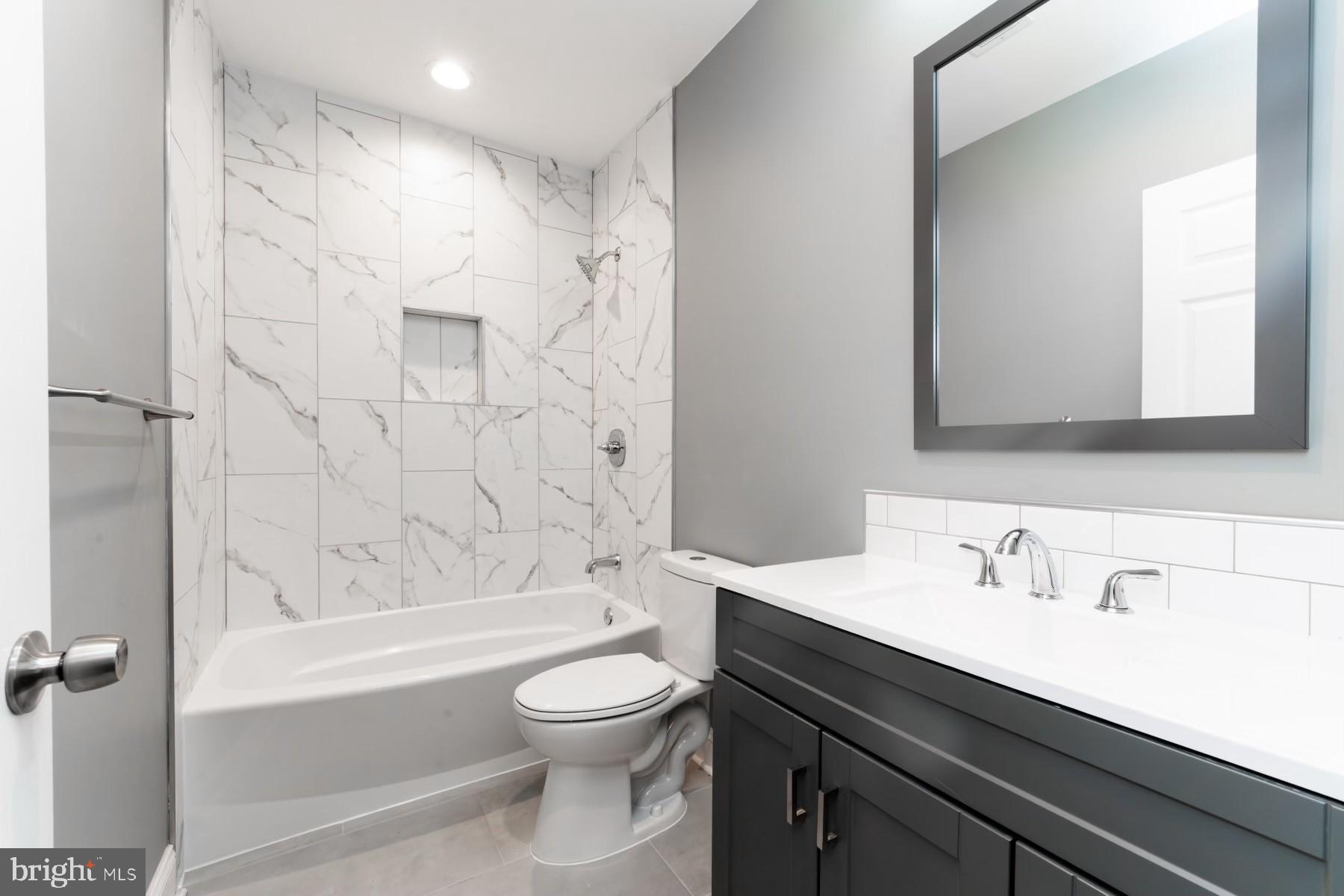 1606 29th Street Southeast Washington, DC 20020 - Photo 2 of 12 a bathroom with a bathtub shower sink vanity mirror and toilet