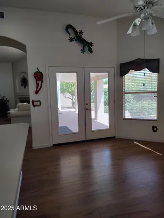 a view of an empty room with a window and wooden floor