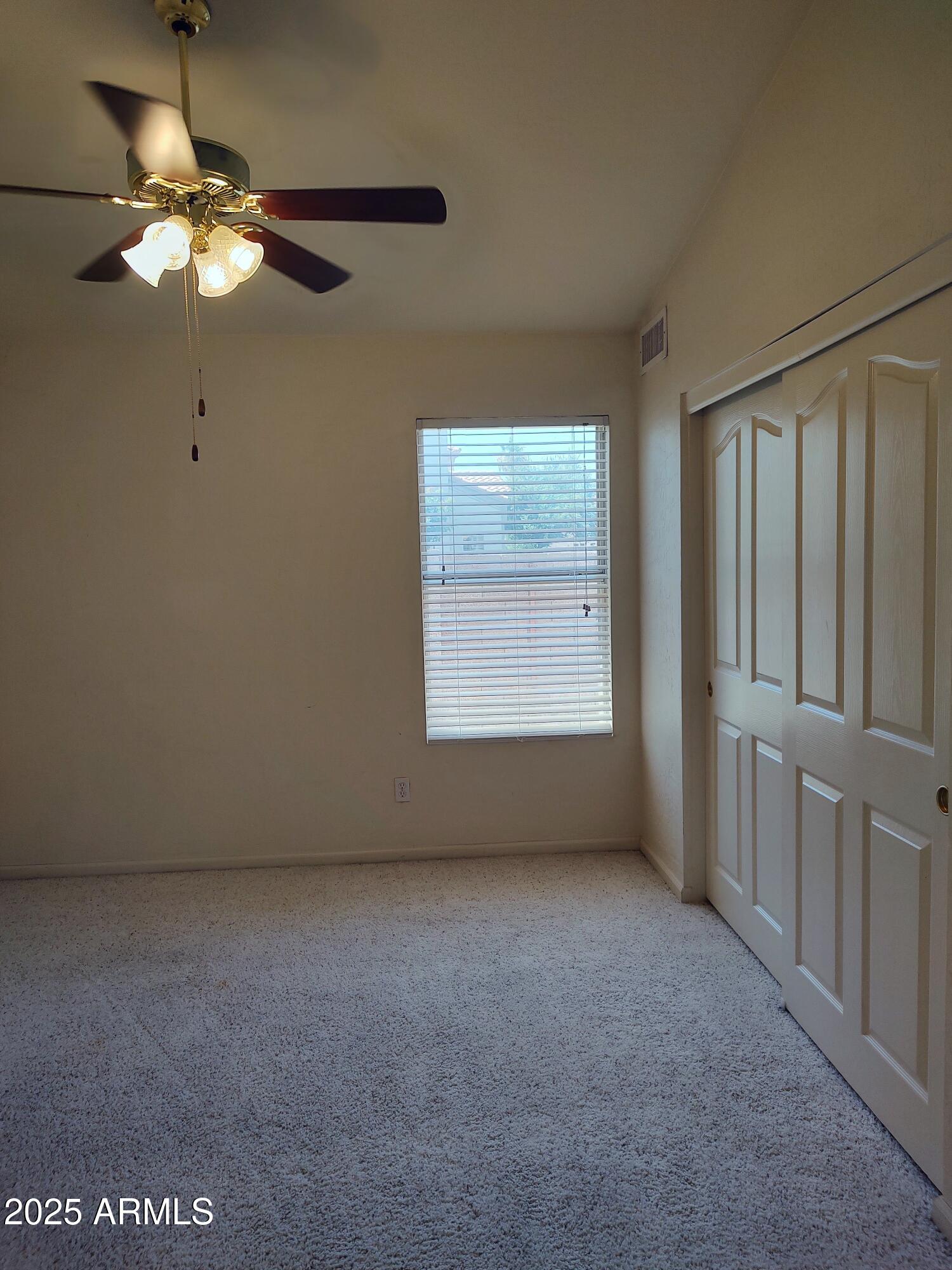 1365 West Courtney Lane Tempe, AZ 85284 - Photo 15 of 24 an empty room with a chandelier fan and windows