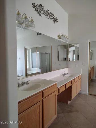 a spacious en suite bathroom with a double vanity sink and a mirror