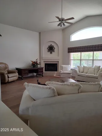 a living room with furniture a fireplace and a large window