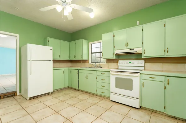 a kitchen with cabinets stainless steel appliances and sink
