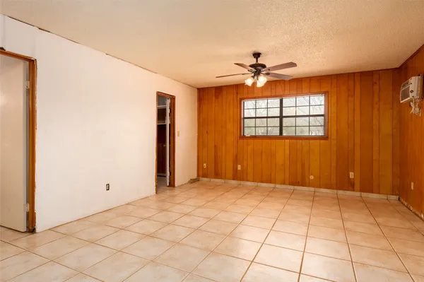 an empty room with windows and fan