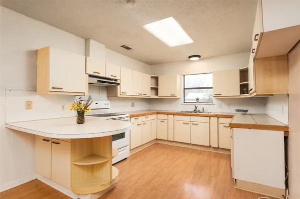 a kitchen with stainless steel appliances granite countertop a sink a stove and cabinets