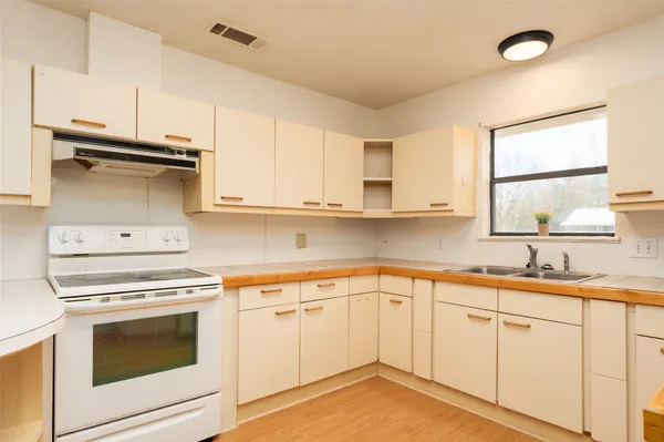 a kitchen with white cabinets and white appliances