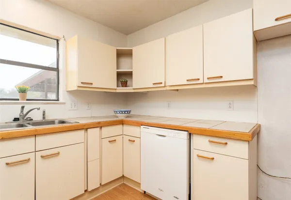 a kitchen with stainless steel appliances white cabinets and a window
