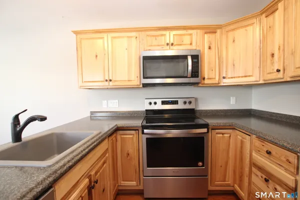 a kitchen with stainless steel appliances granite countertop a sink and a microwave