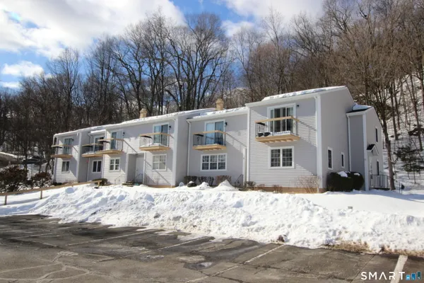a front view of house with yard covered in snow