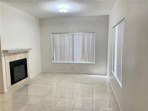 a view of an empty room with a fireplace and a window