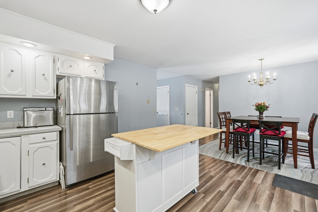 32 Homestead Avenue Greenfield, MA 01301 - Photo 11 of 41 a kitchen with stainless steel appliances granite countertop a refrigerator a stove a dining table and chairs with wooden floor