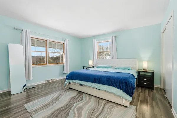 a bedroom with a bed and wooden floor