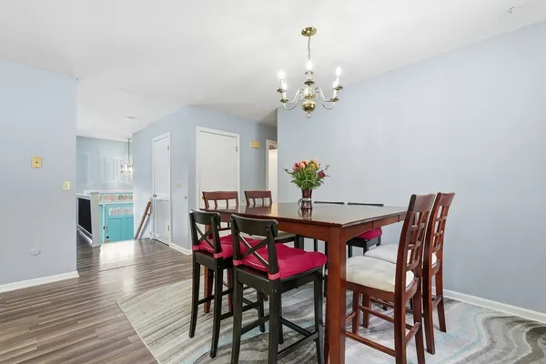 a dining room with furniture a chandelier and wooden floor