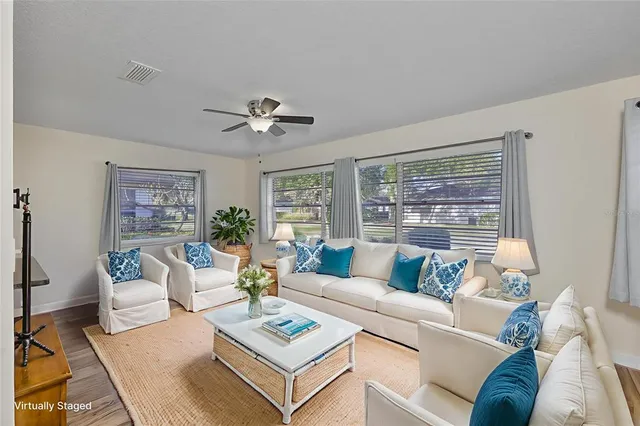 a living room with furniture a table and a large window