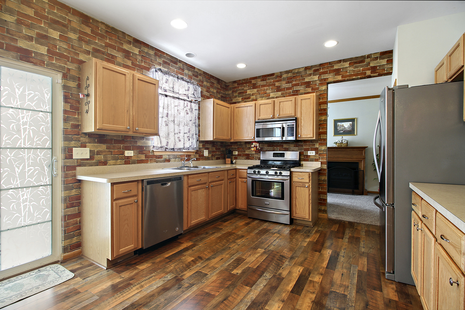 1906 Tallgrass Turn Kankakee, IL 60901 - Photo 7 of 23 a kitchen with stainless steel appliances kitchen island granite countertop a stove a sink and a refrigerator