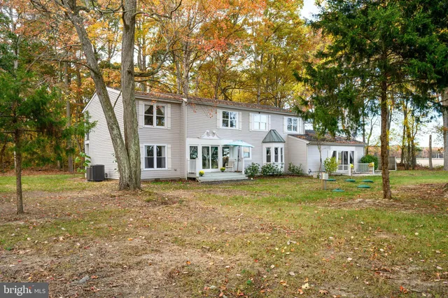 a view of a yard in front of a house with large trees