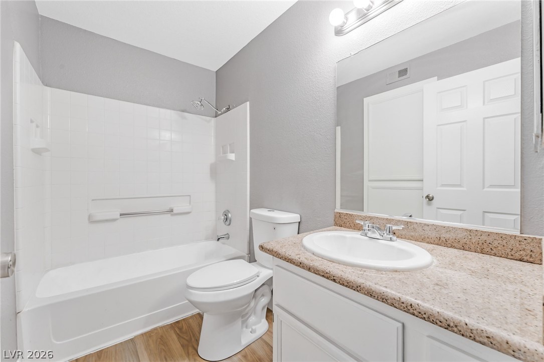 3318 North Decatur Boulevard, Unit 2152 Las Vegas, NV 89130 - Photo 18 of 58 A well-lit bathroom features a functional vanity with a built-in sink and a tub-shower combination.