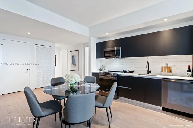 a kitchen with a table chairs sink and cabinets