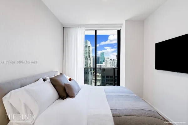 a bedroom with a large bed and a flat screen tv