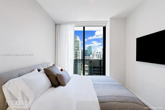 a bedroom with a large bed and a flat screen tv