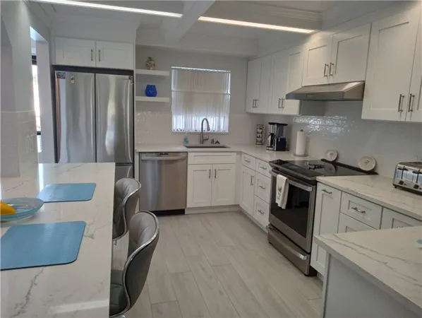 a kitchen with granite countertop white cabinets and white appliances
