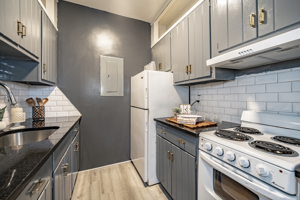 140 Chestnut Street, Unit 310 Springfield, MA 01103 - Photo 11 of 25 a kitchen with granite countertop a stove and a refrigerator