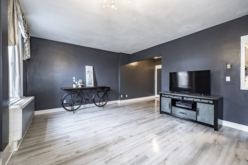 140 Chestnut Street, Unit 310 Springfield, MA 01103 - Photo 4 of 25 a living room with furniture and a flat screen tv