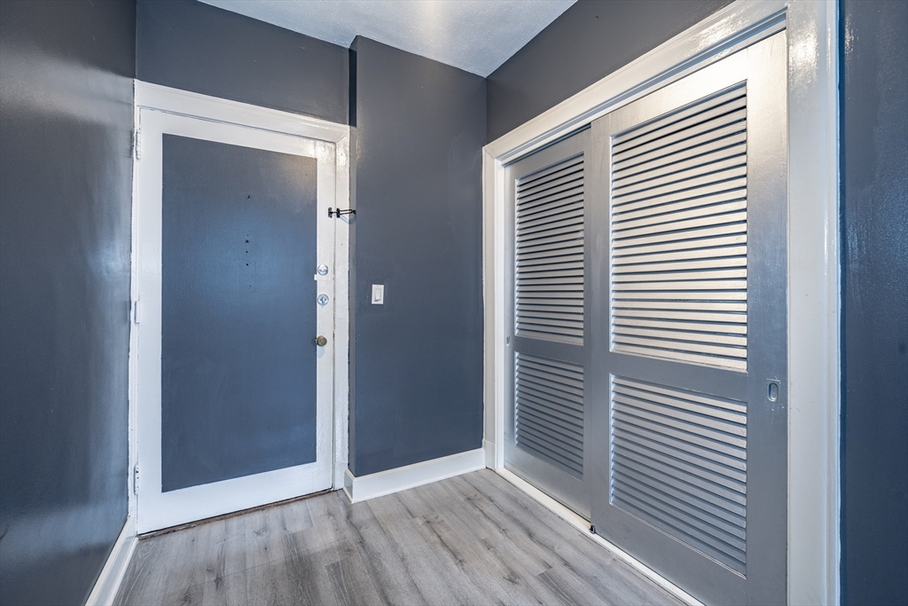 140 Chestnut Street, Unit 310 Springfield, MA 01103 - Photo 5 of 25 an empty room with wooden floor and windows