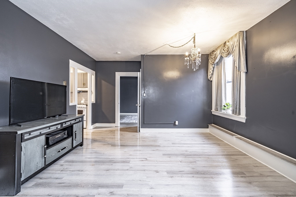 140 Chestnut Street, Unit 310 Springfield, MA 01103 - Photo 8 of 25 a view of livingroom with kitchen and flat screen tv