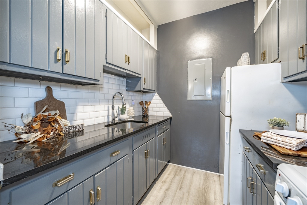 140 Chestnut Street, Unit 310 Springfield, MA 01103 - Photo 10 of 25 a kitchen with granite countertop white cabinets and stainless steel appliances