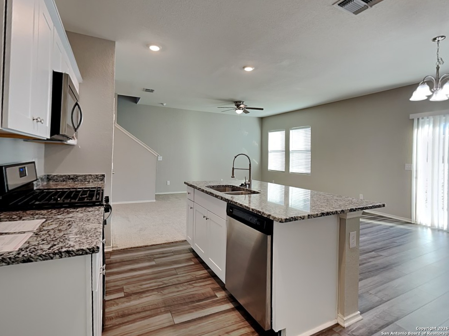 5206 Winding Street St. Hedwig, TX 78152 - Photo 4 of 17 a kitchen with granite countertop stainless steel appliances and wooden cabinets