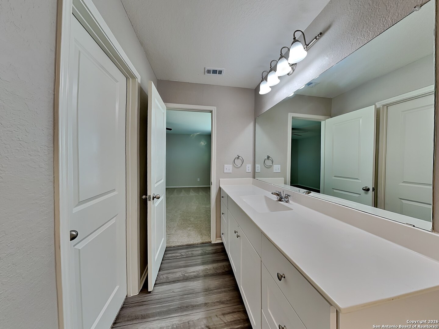 5206 Winding Street St. Hedwig, TX 78152 - Photo 6 of 17 a spacious bathroom with a double vanity sink and a mirror