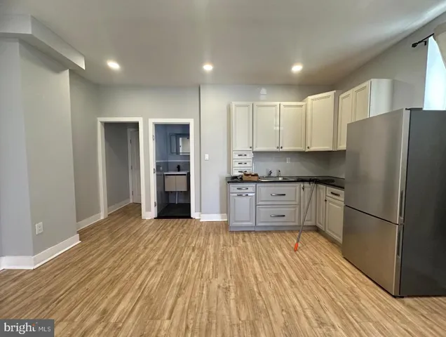 a kitchen with stainless steel appliances granite countertop a refrigerator and a stove top oven