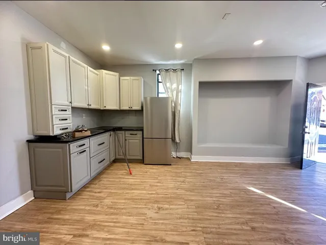 a large kitchen with granite countertop a stove a sink and a refrigerator