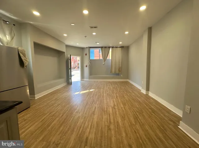 a view of empty room with wooden floor