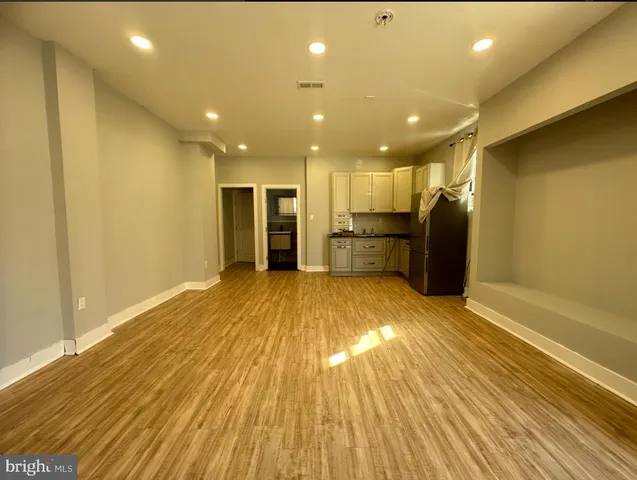 a view of empty room with wooden floor